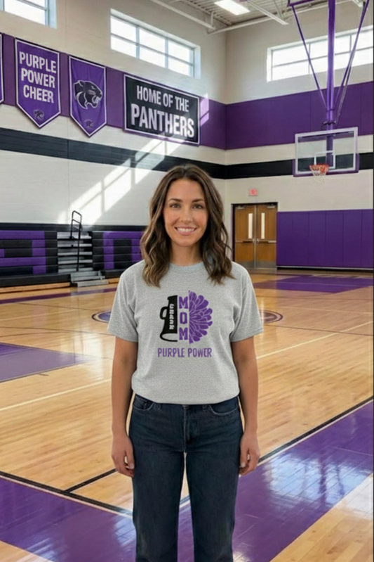 Person wearing a shirt with a logo on a basketball court, with purple and white colors.