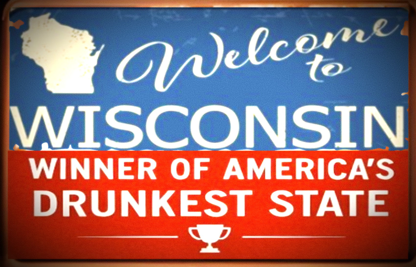Sign with 'Welcome to Wisconsin, Winner of America's Drunkest State' text on a blue and red background.